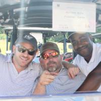 3 men in a golf cart